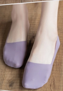 Close-up of seamless ice silk no-show socks in lavender, worn on feet against wood floor