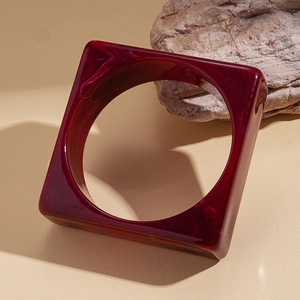 Macro detail of wine red marble texture on square acrylic chunky bangle bracelet