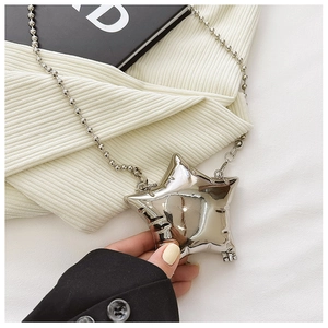 Macro shot of a shiny silver star-shaped mini crossbody bag with a slim bead chain