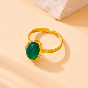 Detail of a gold adjustable ring featuring a vibrant green oval gemstone inlay