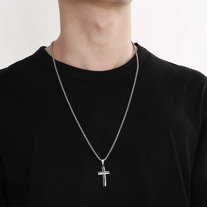 Close-up of a silver stainless steel hollow cross pendant worn on a matching chain