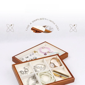Detail view of wooden jewelry tray with six compartments and beige velvet lining