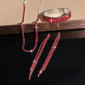 Detailed view of luxury red rhinestone jewelry set with necklace, bracelet and tassel earrings