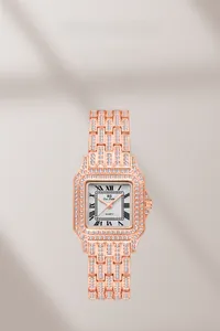 Close-up of rose gold square watch with crystal-encrusted bezel and roman dial