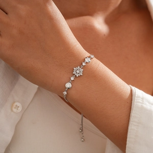 Detail of silver snowflake flower bracelet with zircon stones on model's wrist