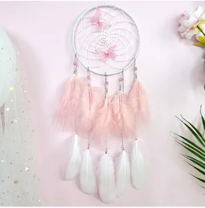 Close-up of handmade dreamcatcher with pink butterflies and soft colored feathers