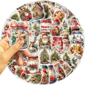Gros plan d'un autocollant de bouteille de Noël avec Père Noël tenu dans la main