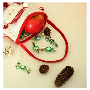 Detail of Christmas Santa burlap gift bag with red apple and festive decorations