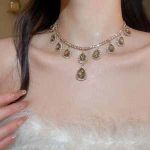 Close-up of elegant champagne drop crystal necklace with diamond halo on model