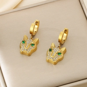 Detailed close-up of golden leopard head earrings with green stones and pavé crystals