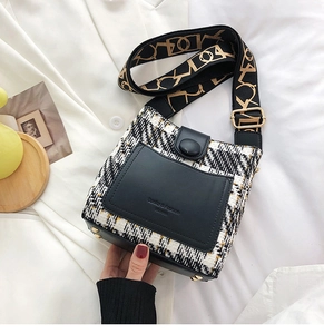 Detail of tweed crossbody bag with leather trim and gold embroidered wide shoulder strap