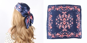 Detail view of navy blue square headscarf featuring vibrant pink and red floral patterns