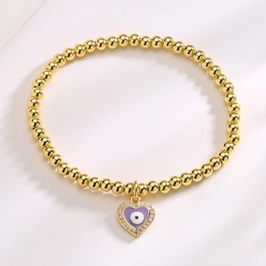 Gold beaded Evil Eye heart bracelet with purple enamel and zircon accents on white background