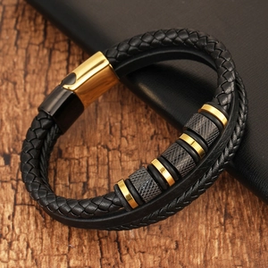 Men's braided leather bracelet with gold and gunmetal magnetic clasp on wood background
