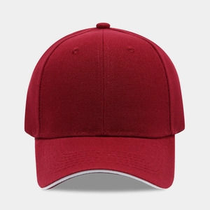 Detail view of burgundy baseball cap featuring a white sandwich brim and twill texture