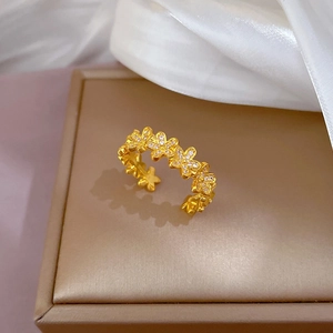 Detailed view of a gold floral ring set with white zircons on a jewelry box display