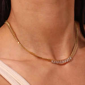 Détail d'un mannequin portant un collier torsadé doré avec des pierres en zircon