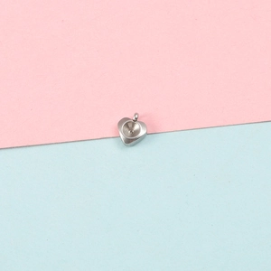 Close-up of heart-shaped stainless steel pendant base with circular textures