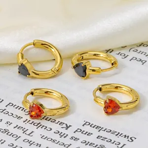 Titanium steel heart earrings in gold with black and red zircon stones on a white fabric