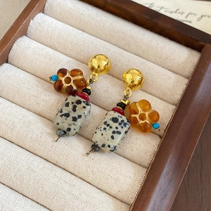 Close-up of bohemian earrings with resin flowers and Dalmatian Jasper in a jewelry box