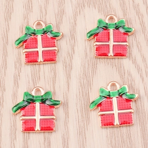Close-up of alloy Christmas gift box charms with red enamel and green bows for jewelry DIY
