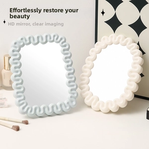 Detail of minimalist desktop makeup mirrors with wave frames in cream and blue tones