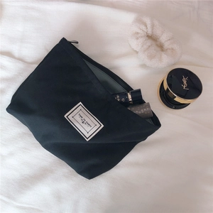 Close-up of black canvas cosmetic bag with Time to Party label and zip closure
