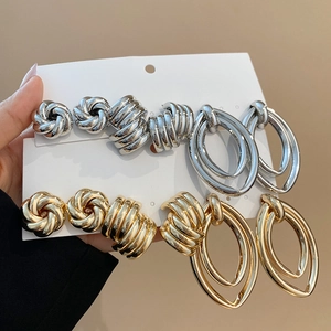 Detailed comparison of gold and silver metallic stud earrings in knot and spiral designs