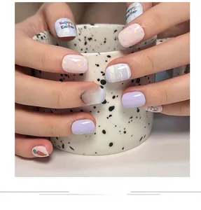 Close-up of Easter press-on nails with cute bunny, carrot patterns and Happy Easter text