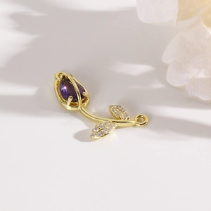Macro view of gold-plated tulip flower connector with a purple teardrop crystal for DIY jewelry