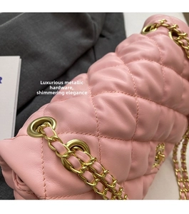 Detail shot of pink quilted leather bag featuring gold-tone chain and hardware