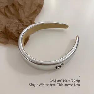 Detailed view of silver PU leather headband with metallic finish and three star accents
