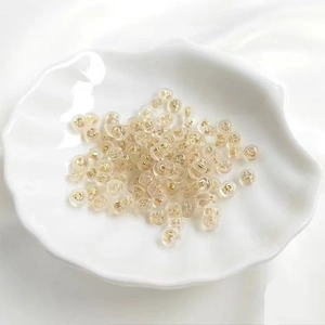 Silicone earring backings with gold metal core on a white plate for jewelry making