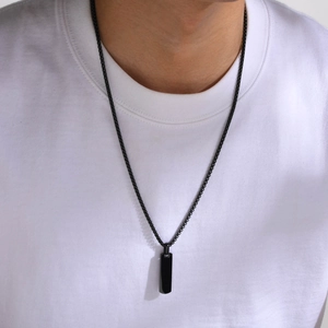 Detailed view of men's minimalist black stainless steel rectangle pendant on a box chain