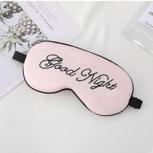Detail of pink silk sleep mask with Good Night embroidery and adjustable strap