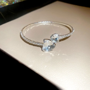 Macro shot of silver open cuff bracelet with dual heart zircon and pavé setting