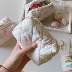 Détail d'une trousse à maquillage matelassée en coton avec motifs fraises et fermeture