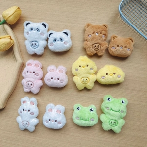 Flat lay of colorful plush animal charms including bears and rabbits on wood