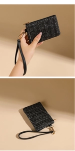 Detail of black woven straw texture coin purse with leather wristlet and gold hardware