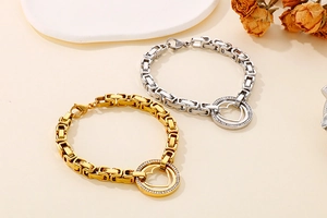 Détail de bracelets cœur en or et argent avec zircons pavés sur décor pierre