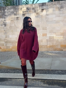 Close-up of wine red chunky cable-knit wool sweater with thick textured patterns