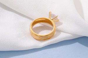 Detailed side view of a gold titanium ring with textured band and a large round crystal