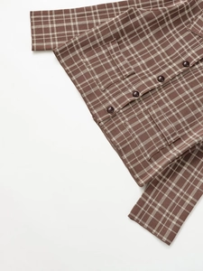 Detail of brown plaid knit cardigan featuring dark buttons and functional front pockets