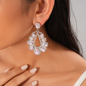 Close-up of elegant teardrop earrings with pink pear-shaped gems worn by a model