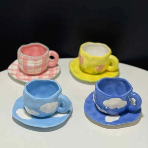 Hand-painted ceramic coffee cup and saucer set featuring grid, tulip, and cloud patterns