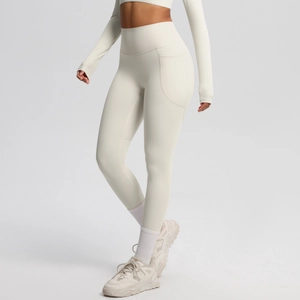 Detail view of high-waisted yoga leggings in cream with practical side pocket design