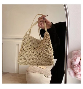 Detail of hollow floral woven pattern and tight straw weave texture on crossbody bag