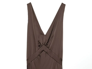 Close-up of deep V-neckline and gathered pleat details on a brown satin dress