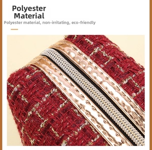 Detail aus rotem Tweed-Polyestergewebe mit Goldfaden und hochwertigem Reißverschluss