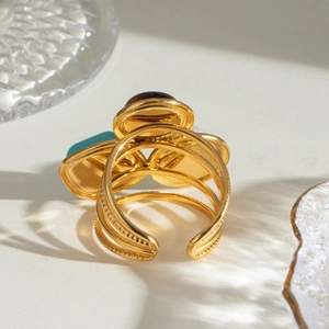 Detail of adjustable gold multi-layer ring featuring turquoise, tiger eye and white stones